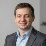 Портрет уверенного российского бизнесмена в студийном освещении на нейтральном размытом фоне для сайта